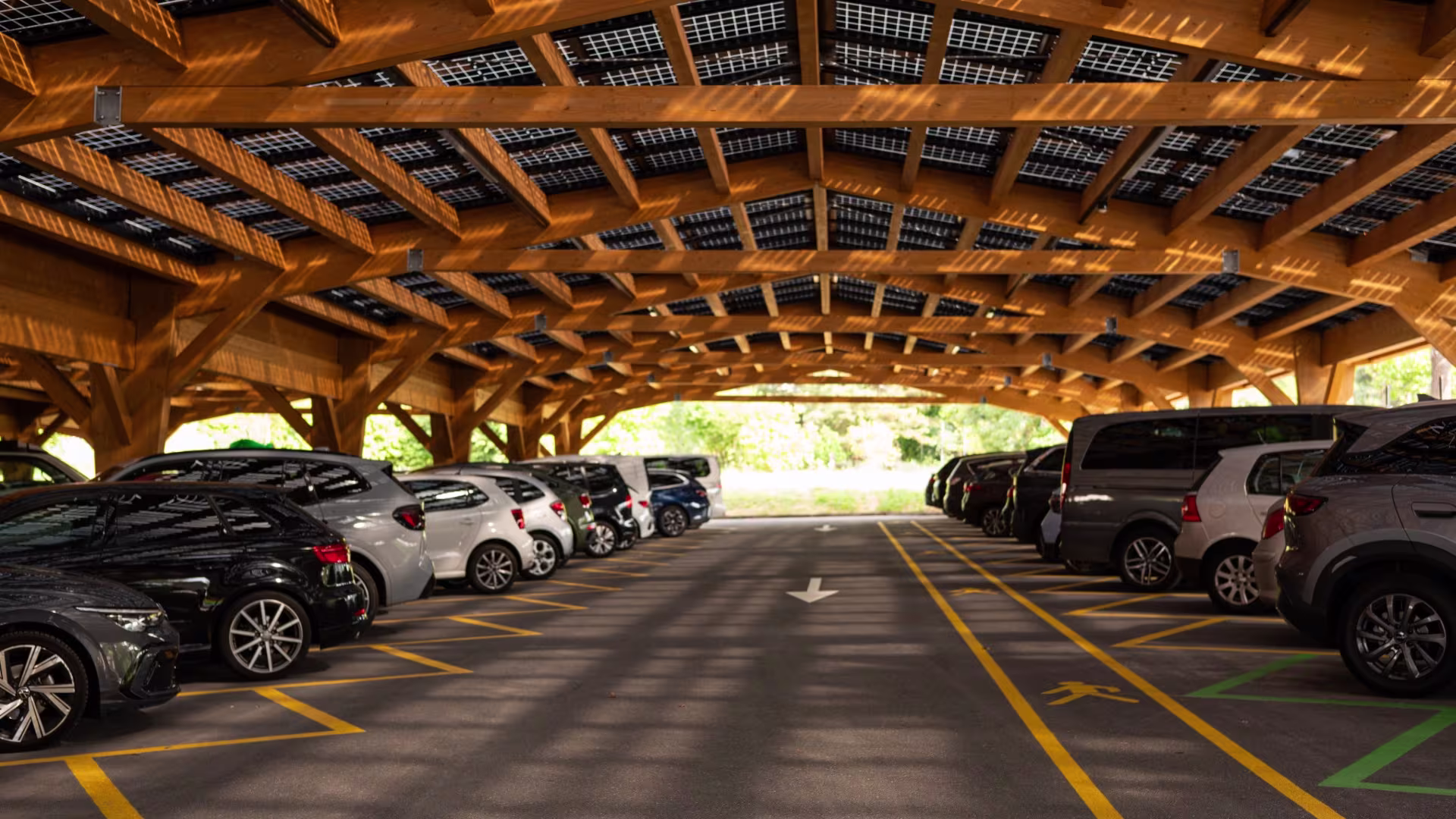 Elektrofahrzeug lädt an einer Ladestation unter einem überdachten Parkplatz