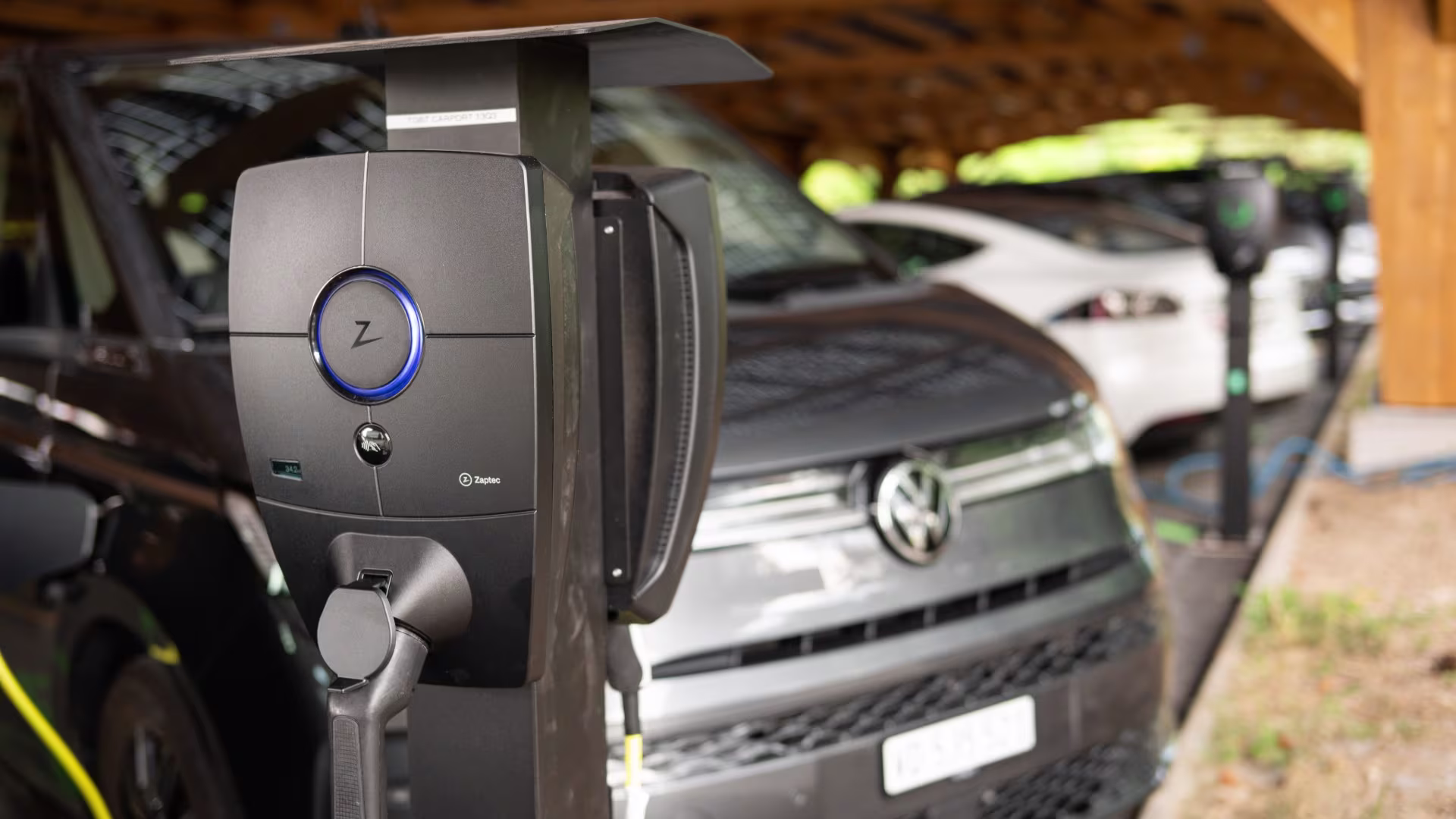 Überdachter Firmenparkplatz mit Photovoltaik-Dach und zahlreichen parkierten Fahrzeugen