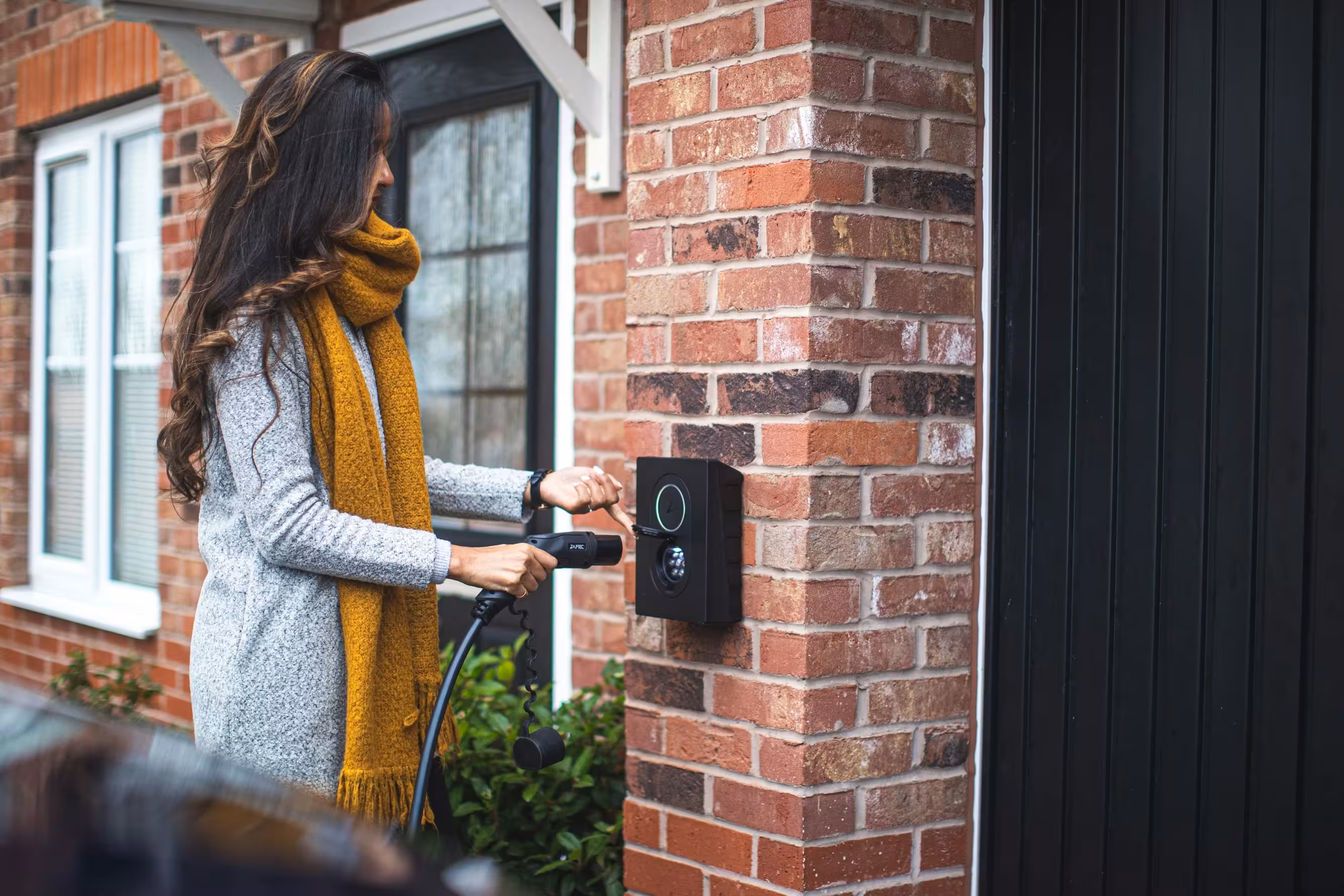 Person charging an electric vehicle at a wallbox