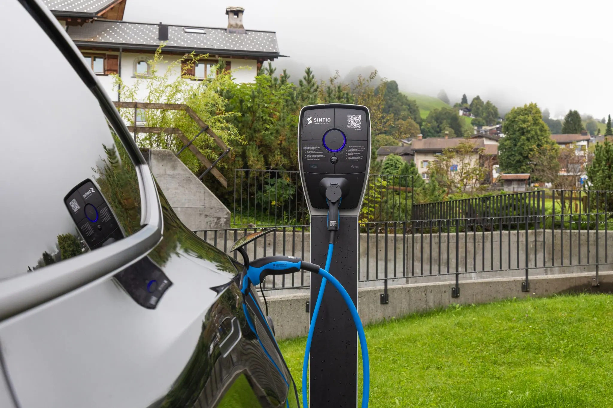 Sintio charging station in a residential area next to a parked car